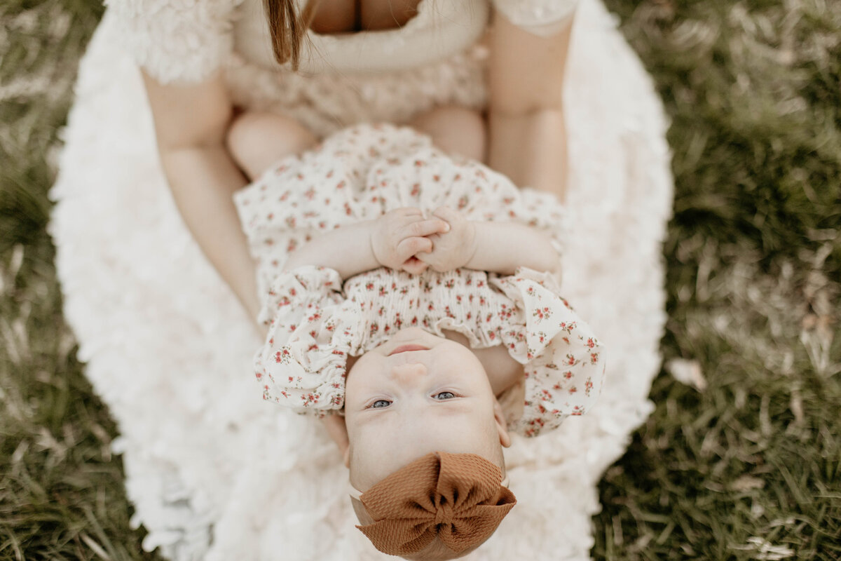 Close up of baby lying on mom's lap.