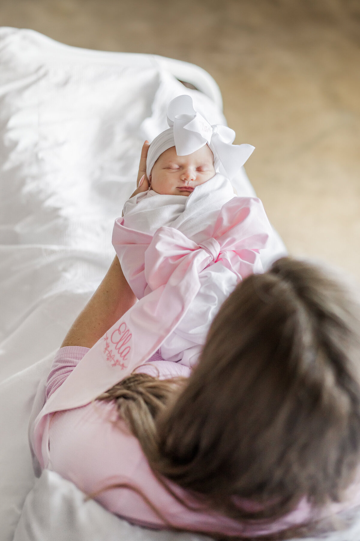 Mother gently cradling her newborn baby, both looking content and serene in a hospital setting during fresh-48 session