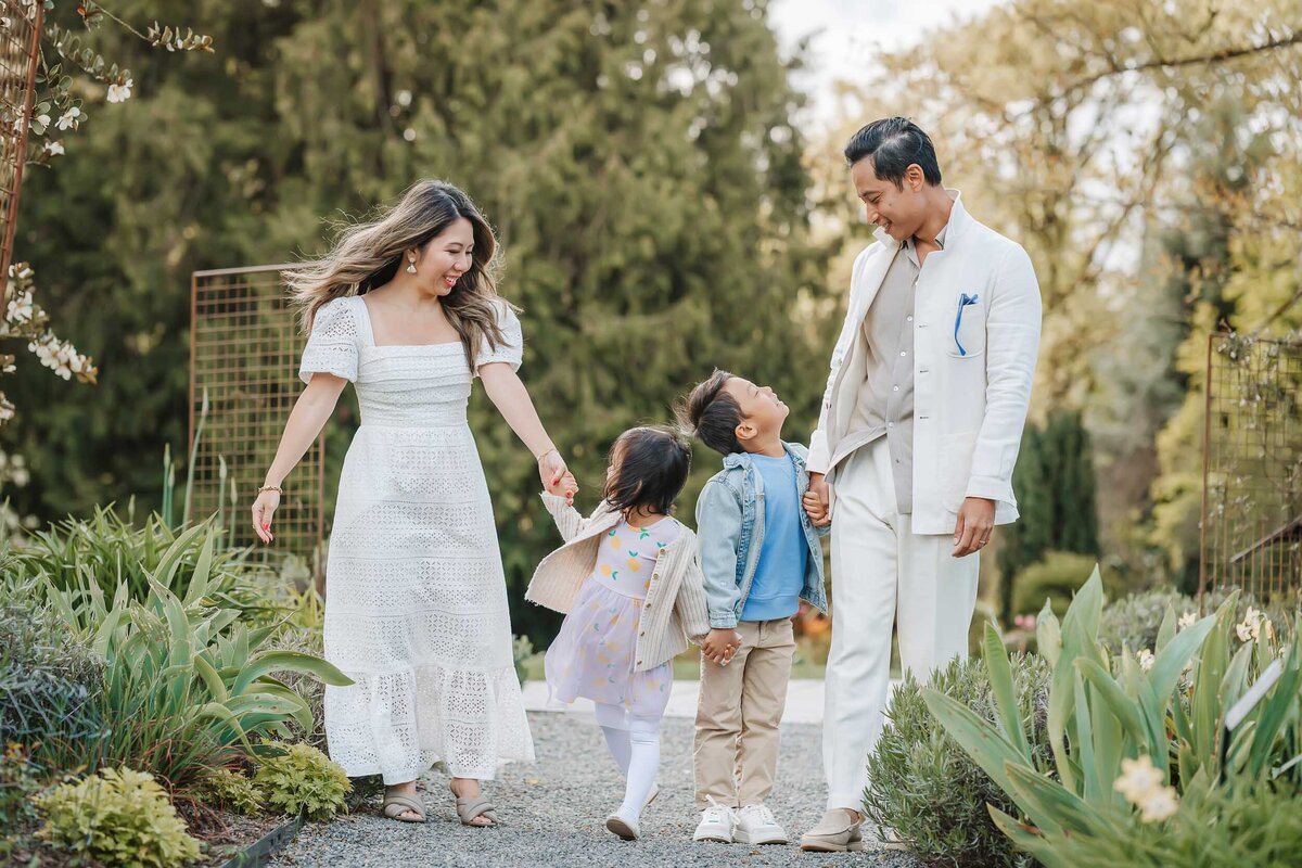 Emotive photo of a family sharing a loving glance at Bellevue Botanical Garden, surrounded by vibrant spring colors.