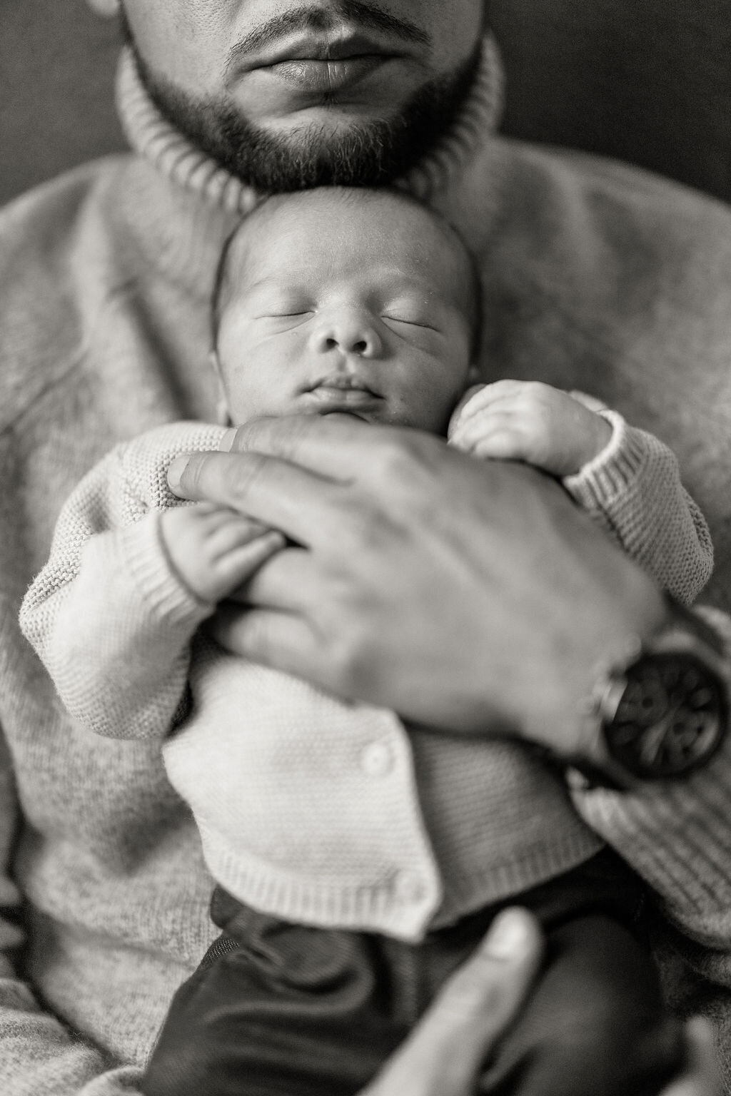 Father cradling his newborn baby in a quiet, tender moment during an in-home session in Boca Raton, Florida.