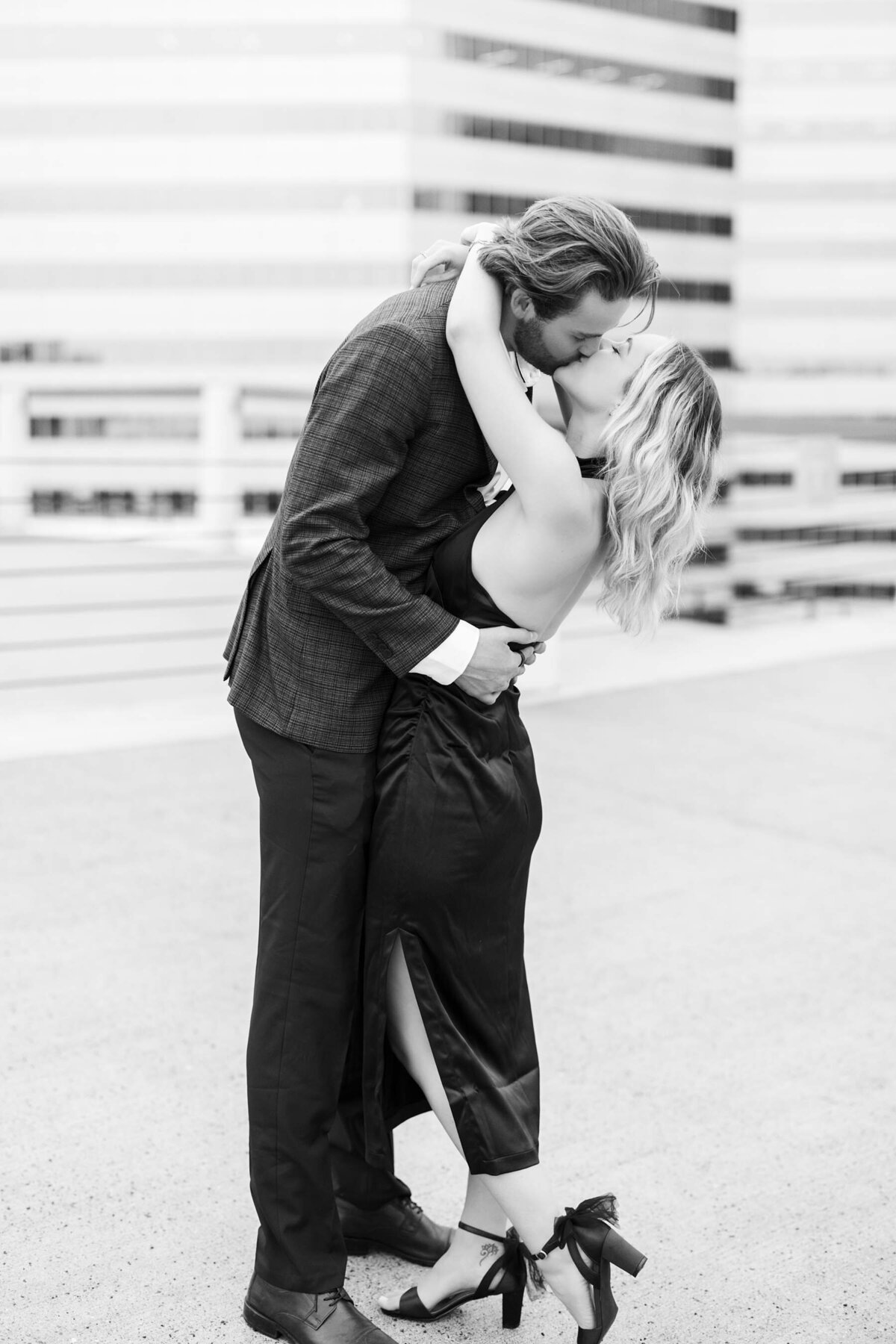 Minneapolis engagement photography captures the passion between a couple with a romantic kiss, set against the city's backdrop