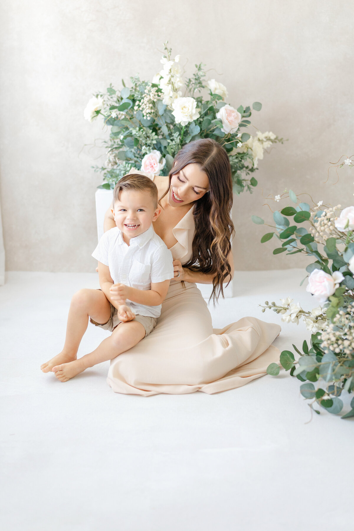 Joyful Tampa motherhood portrait of mom and son laughing together in soft natural light studio