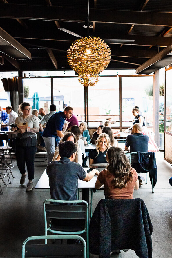 Group of people visit at tables at a restaurant in Denver, Colorado.