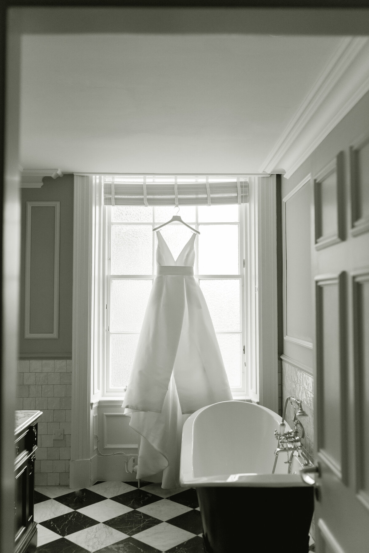Jesus Peiro wedding gown hanging in bathroom of Gleneagles Hotel on a wedding day summer 2025.  Image by luxury fine art wedding photographer, Scotland, Jill Cherry Porter.
