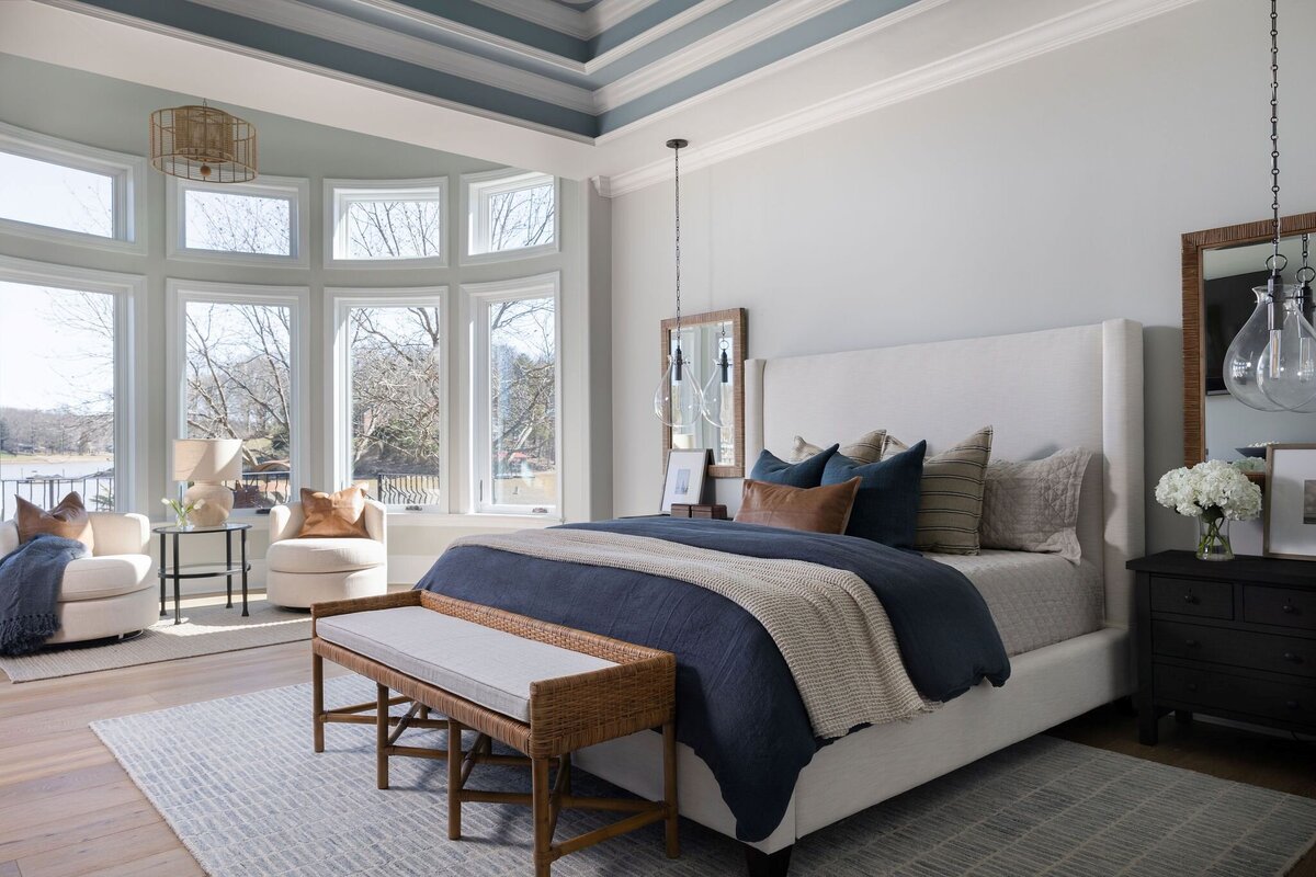 modern bedroom with blue and leather accents, lots of natural light, and high ceilings