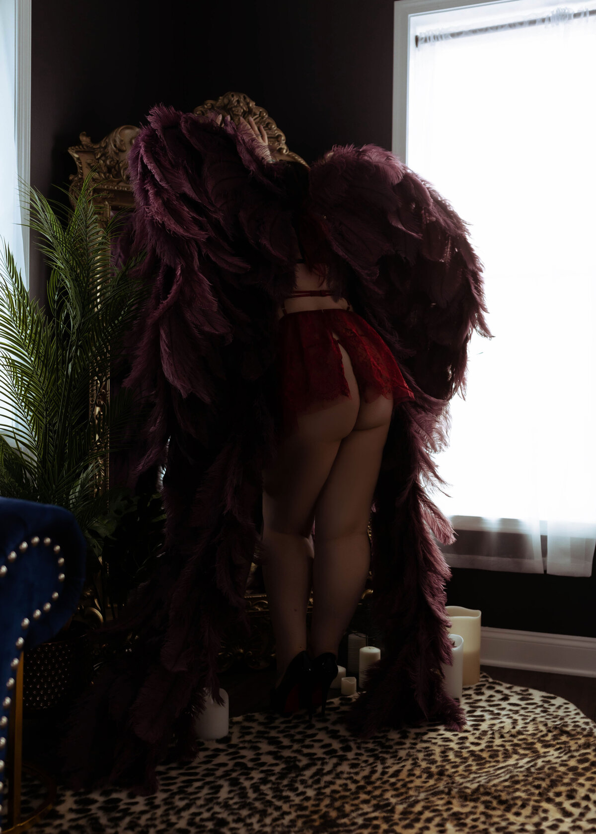 woman standing in red lingerie with angel wings on back