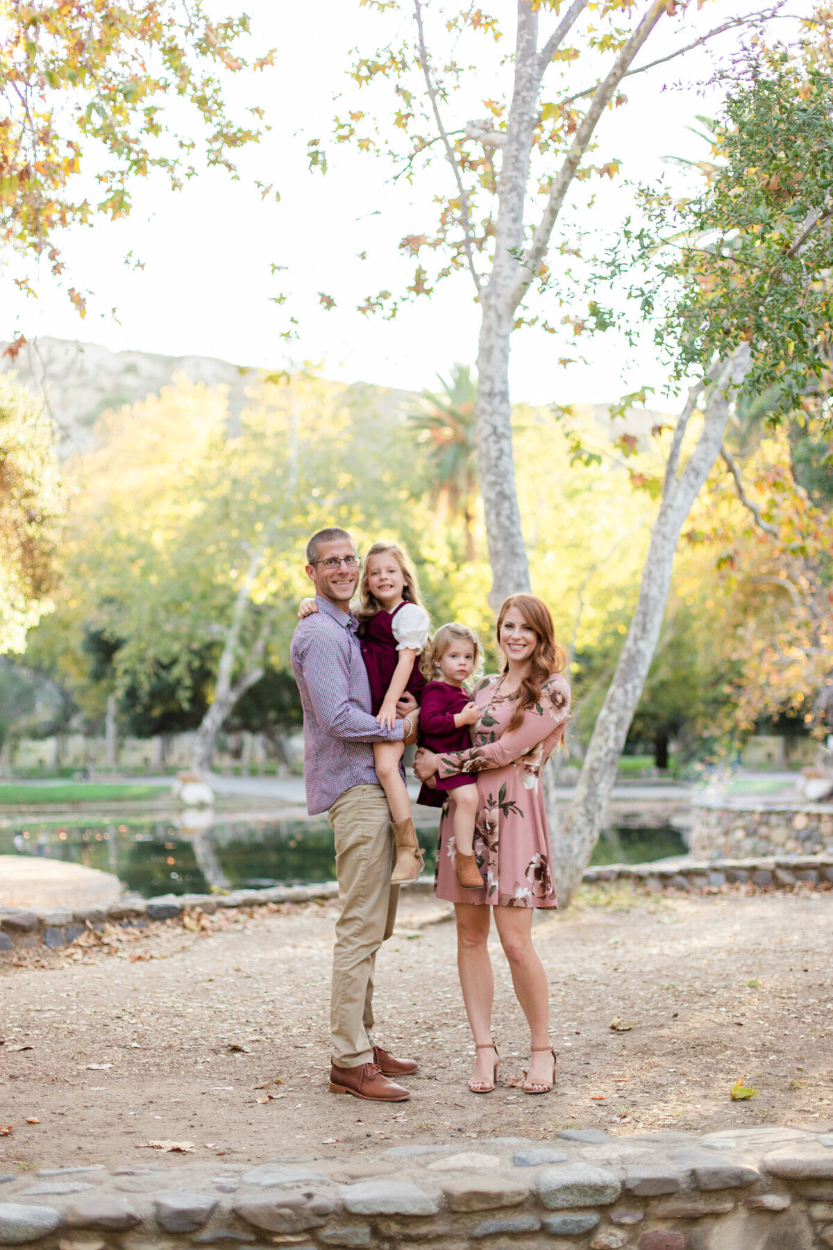 smiling mom and dad holding daughters