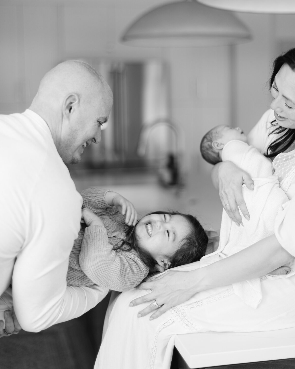 Candid moment of family of 4 in their kitchen