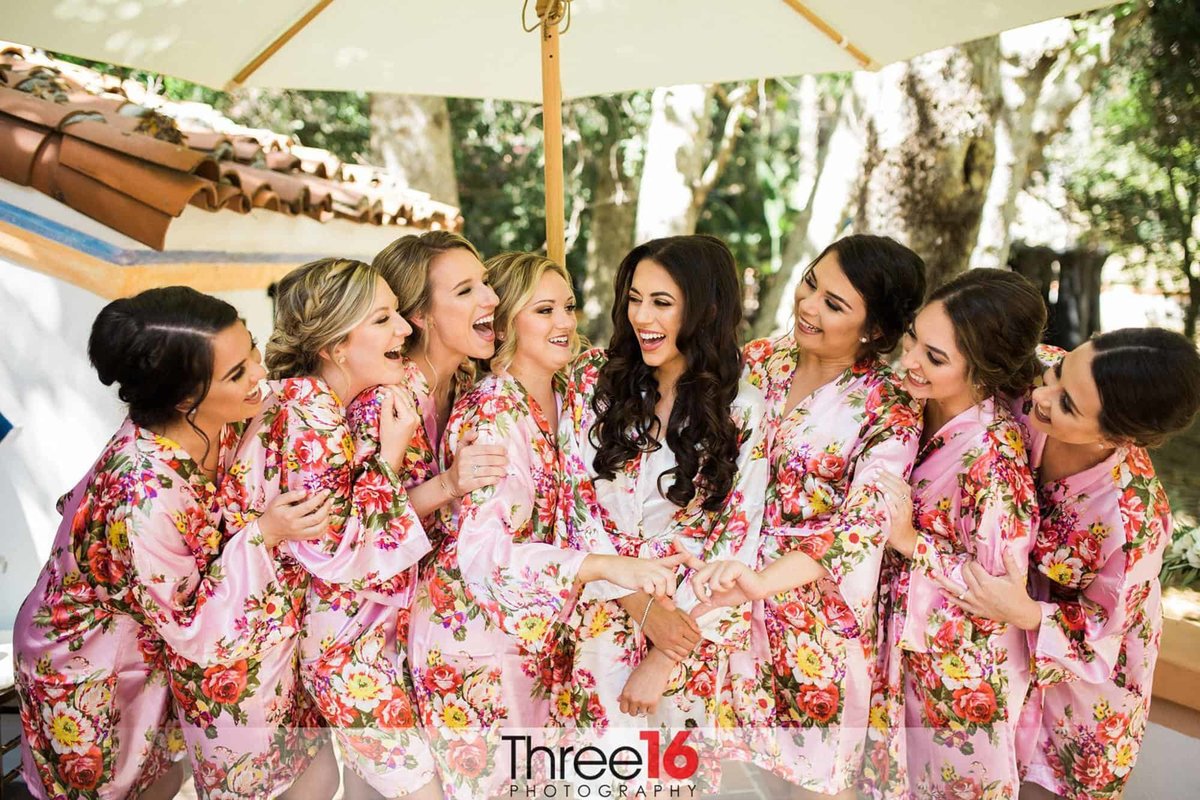Bride and her Bridesmaids enjoy a laugh together before getting dressed for the wedding
