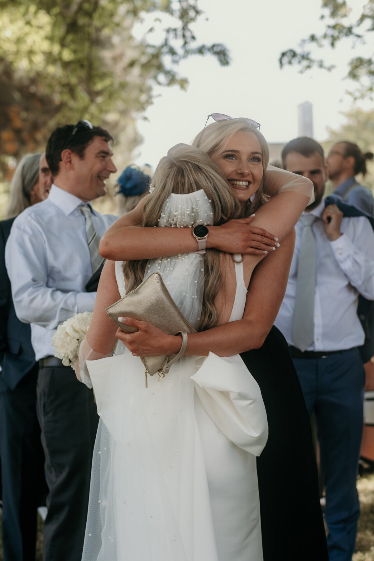 Die Braut umarmt einen weiblichen Gast.
