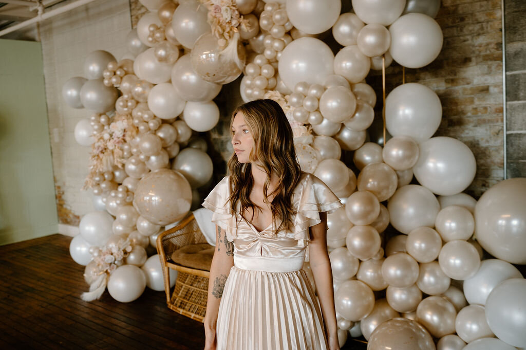 Elegant white balloon arch with a female model, ideal for luxury events or weddings.