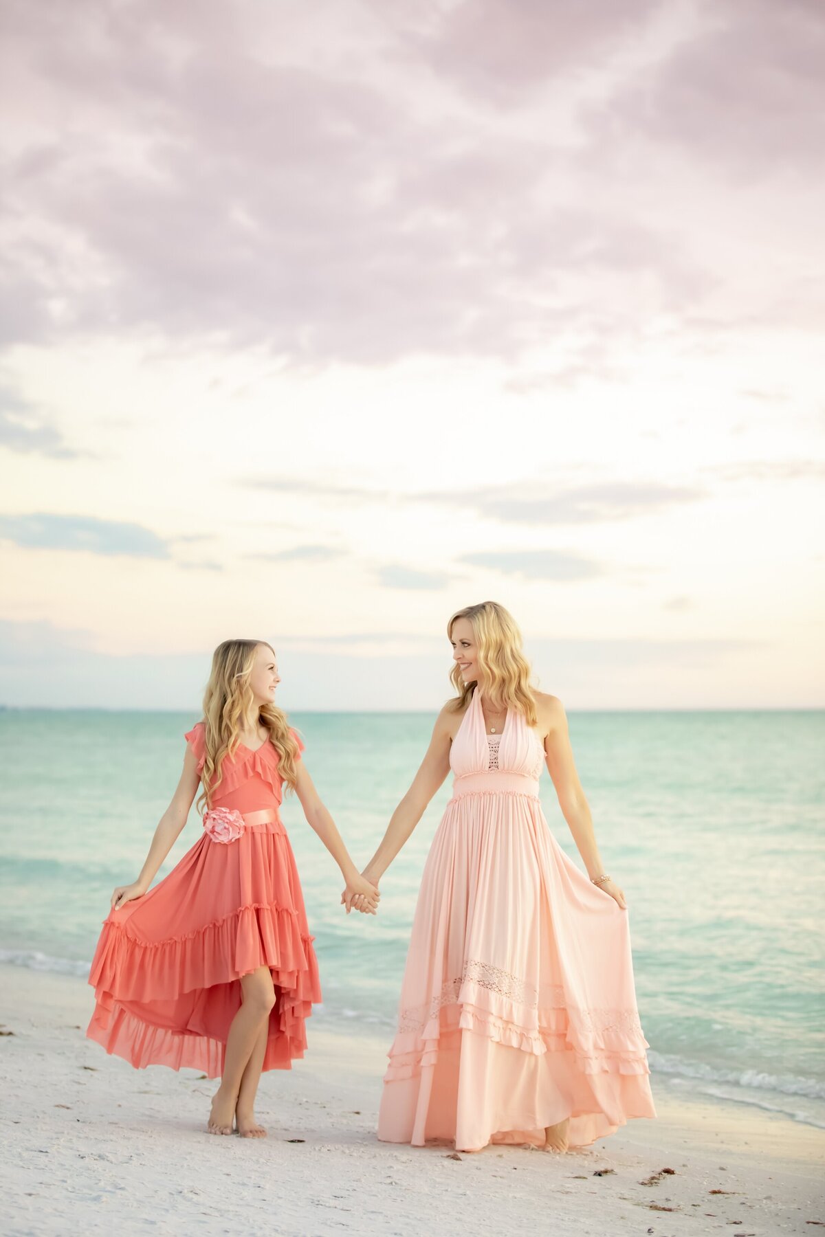 mother daughter portrait at the beach in pretty pink and coral dresses