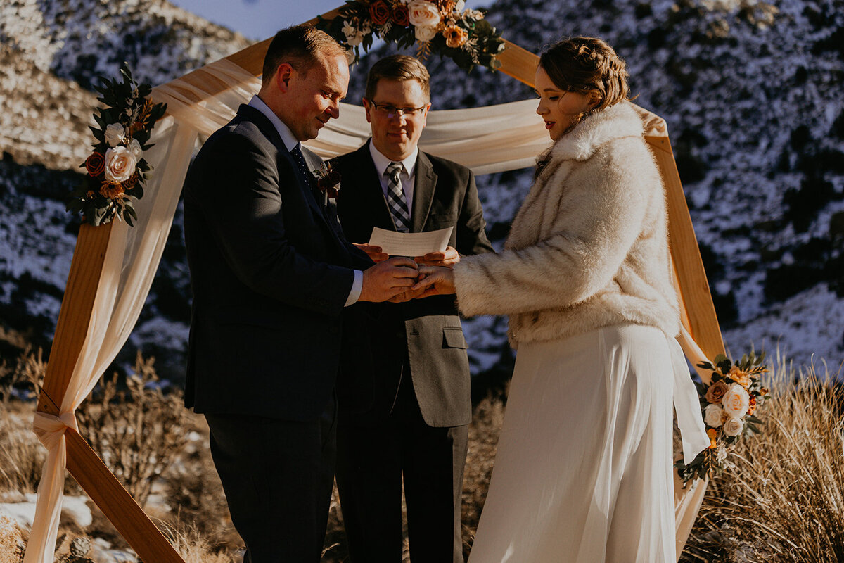 bride and groom having their ceremony on the snowy Sandia Mountains in Albuquerque
