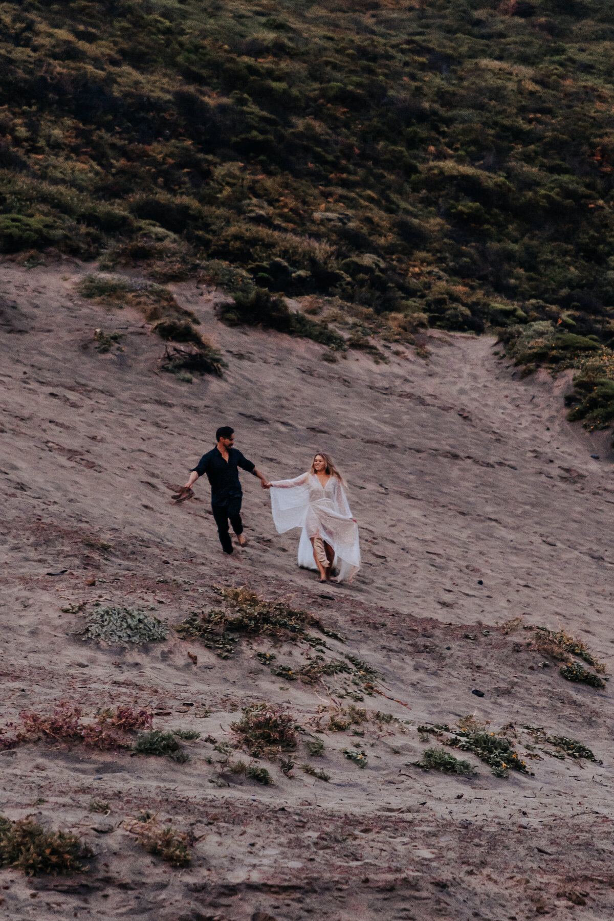 Destination elopement photographer captures couple running on beach after elopement