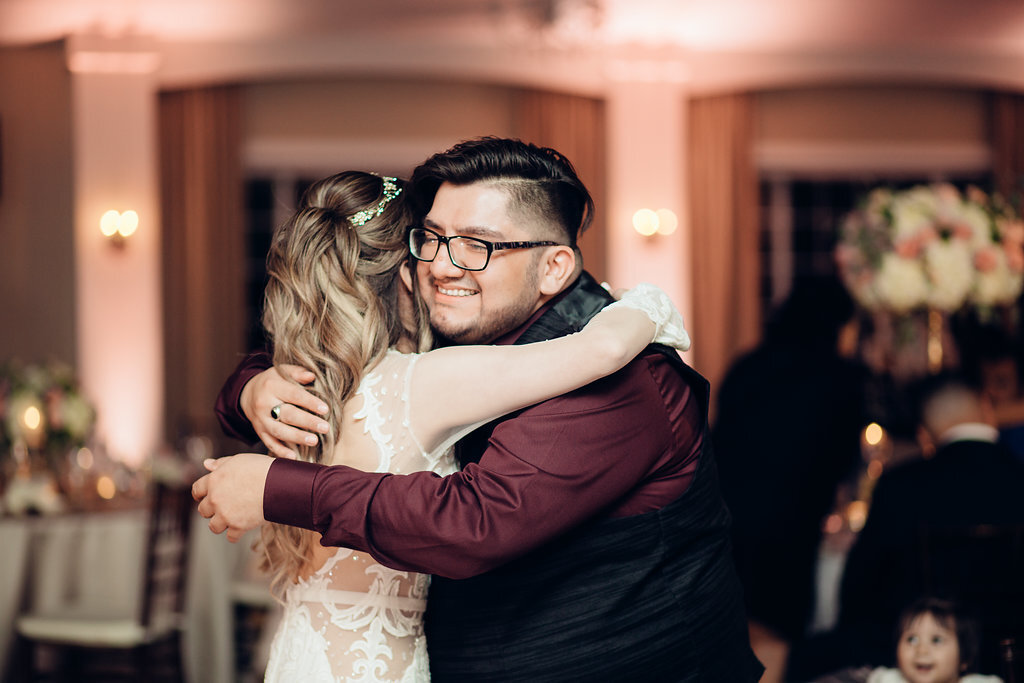 Wedding Photograph Of Bride Hugging a Man In Black And Maroon Suit Los Angeles