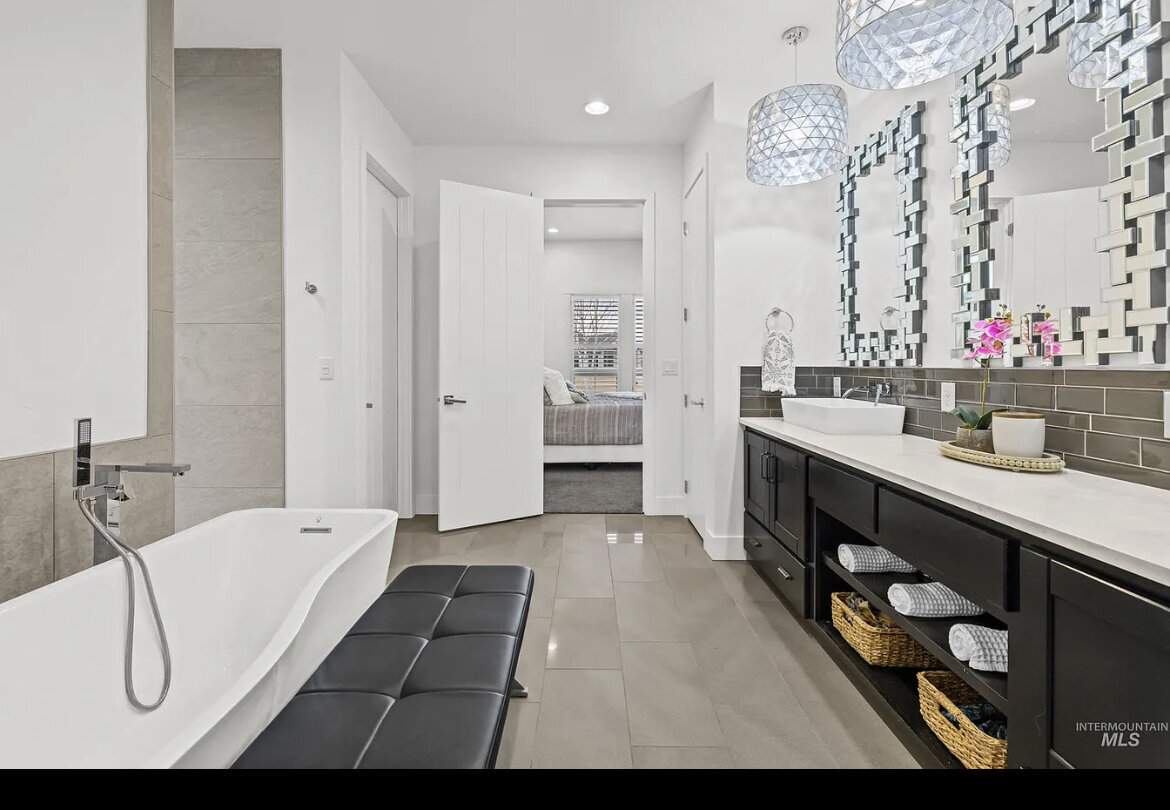 bathroom with black cabinets silver mirrors bathtub