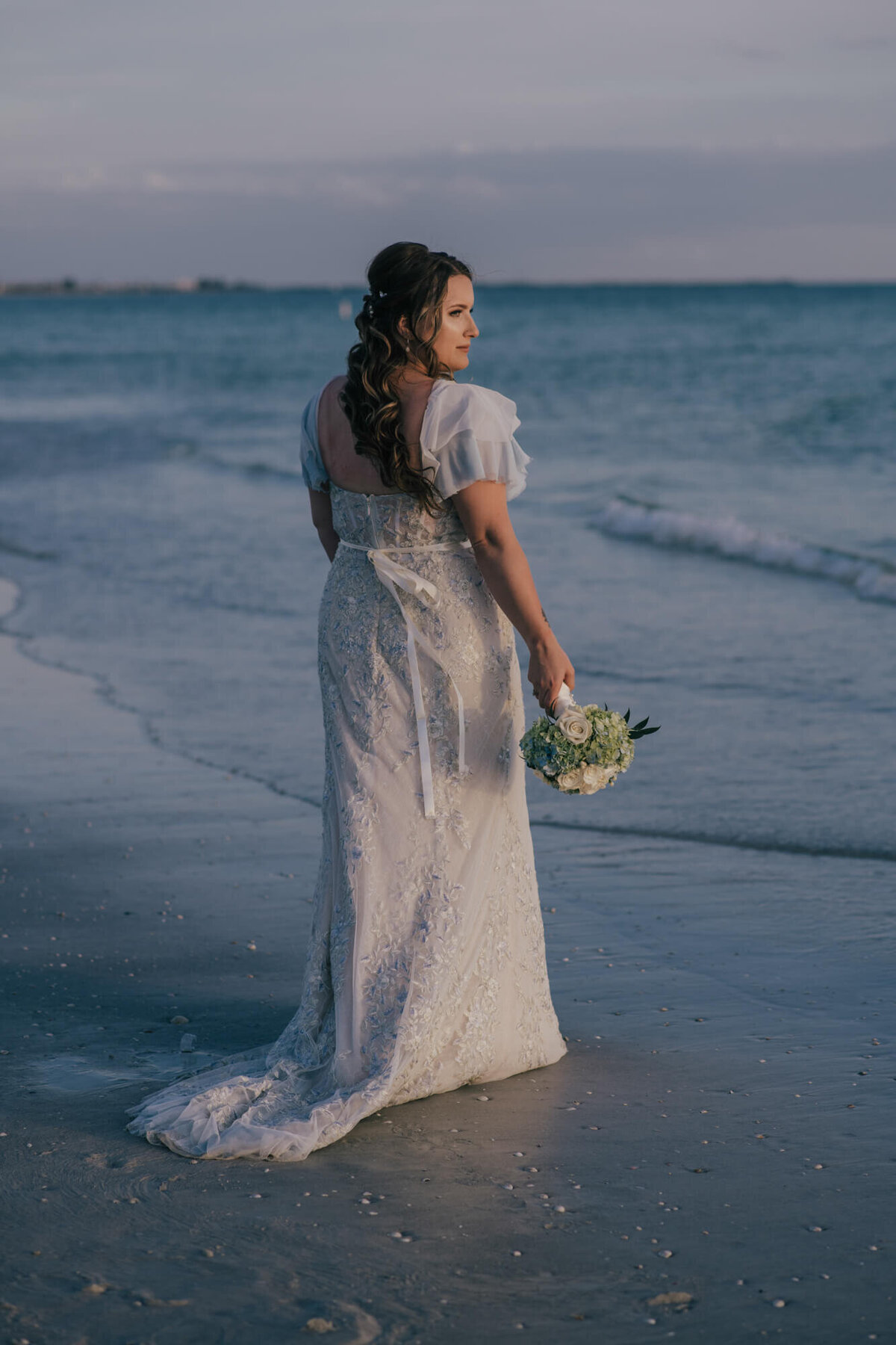 Bride standing on beach