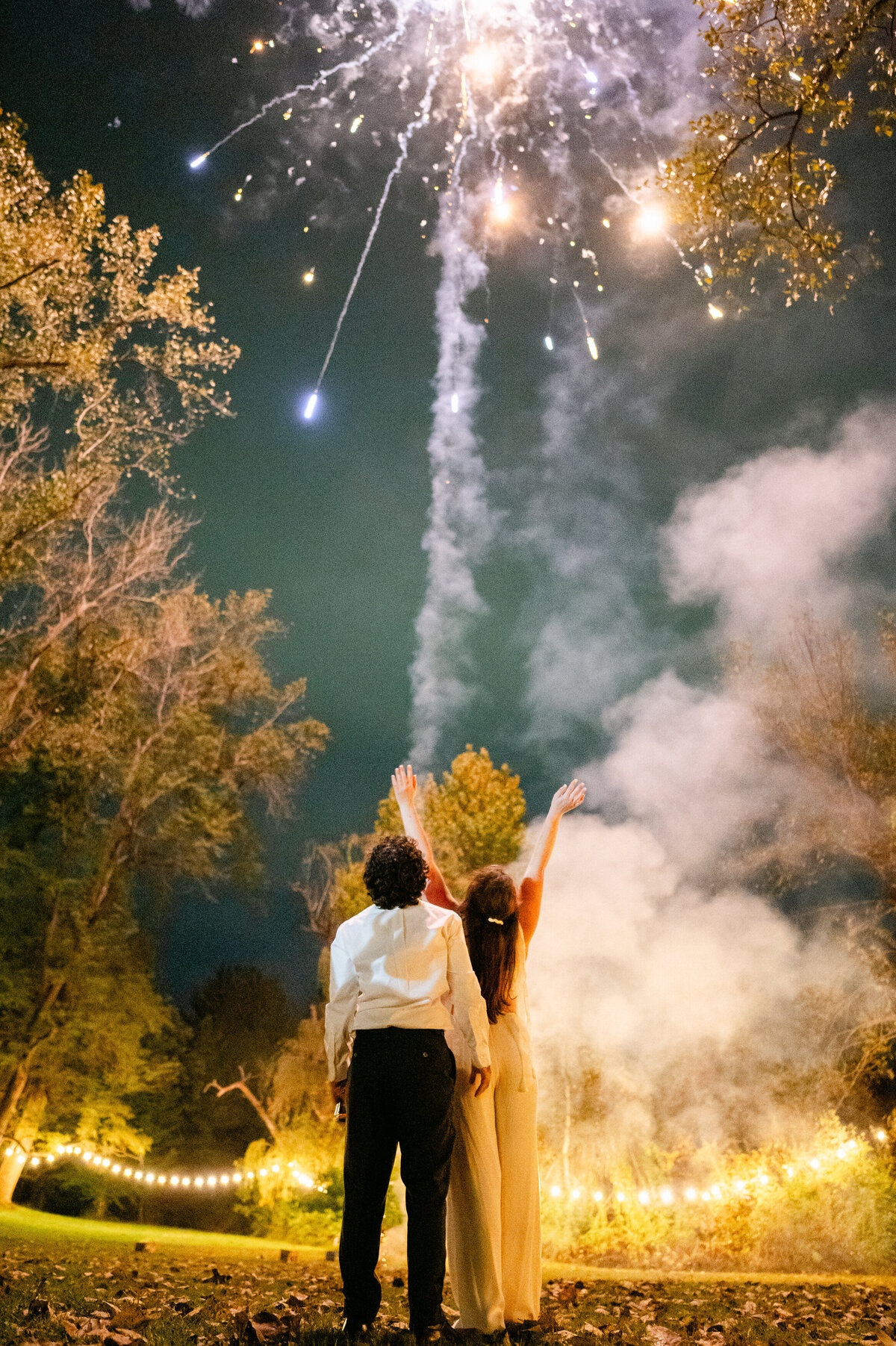 Bride and groom looking up at fireworks