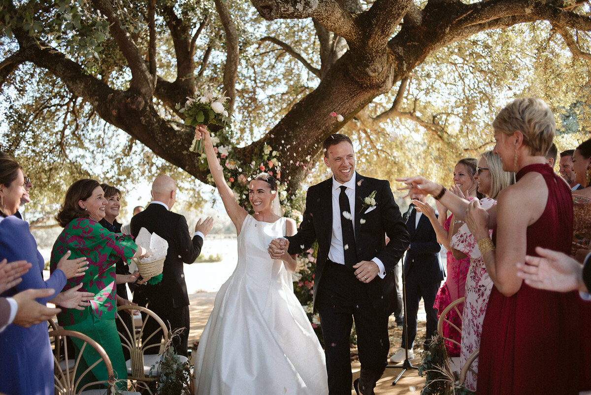 The married couple walking together down the aisle