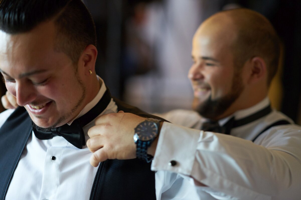 Best man putting on groom's vest