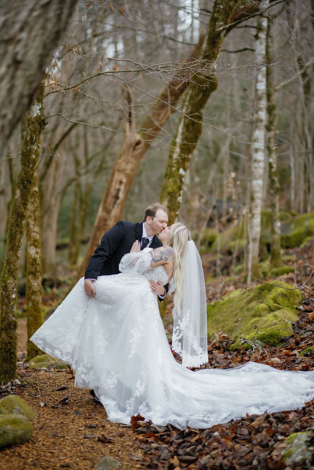 gatlinburg photographers captures couple eloping to Gatlinburg with groom dipping his bride backwards and kissing her at Elys Mill wedding venue 