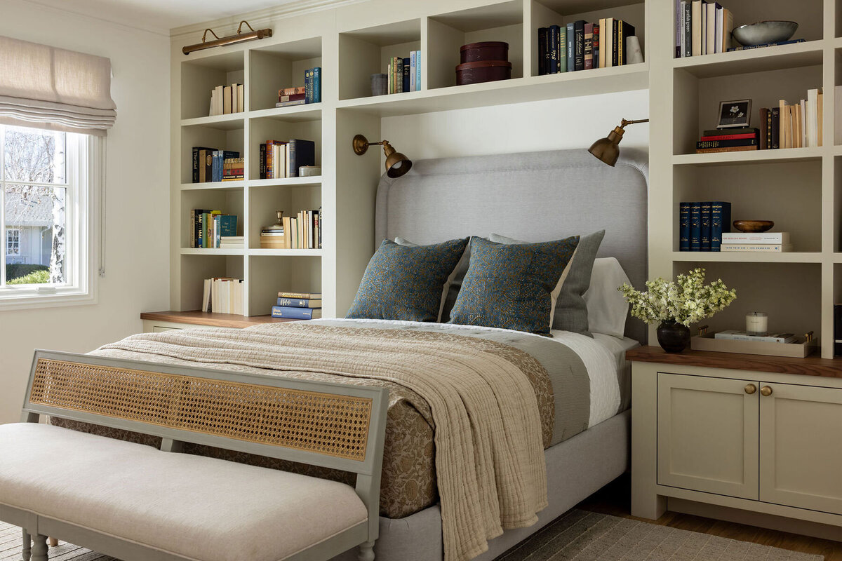 Timeless design of a bedroom with built-in shelving around the headboard and soft, warm color palette by a Newport Beach interior designer