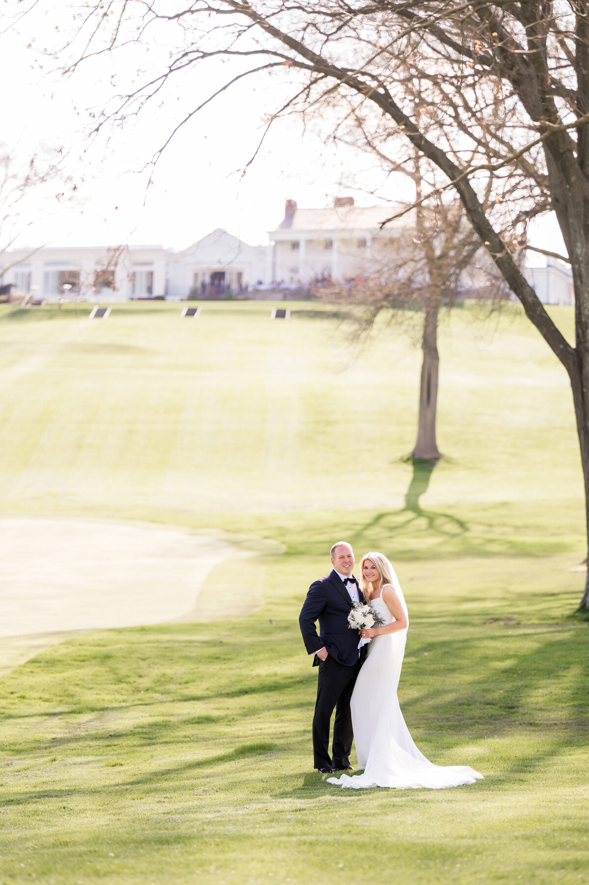 married couple posing for wedding picture on the golf course at the pittsburgh field club