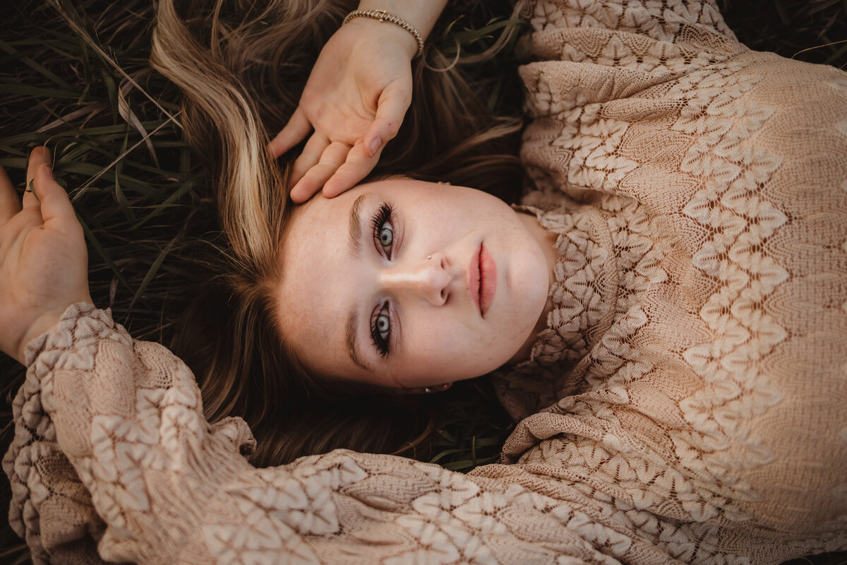 SENIOR LAYING IN GRASS WITH TEXTURED DRESS