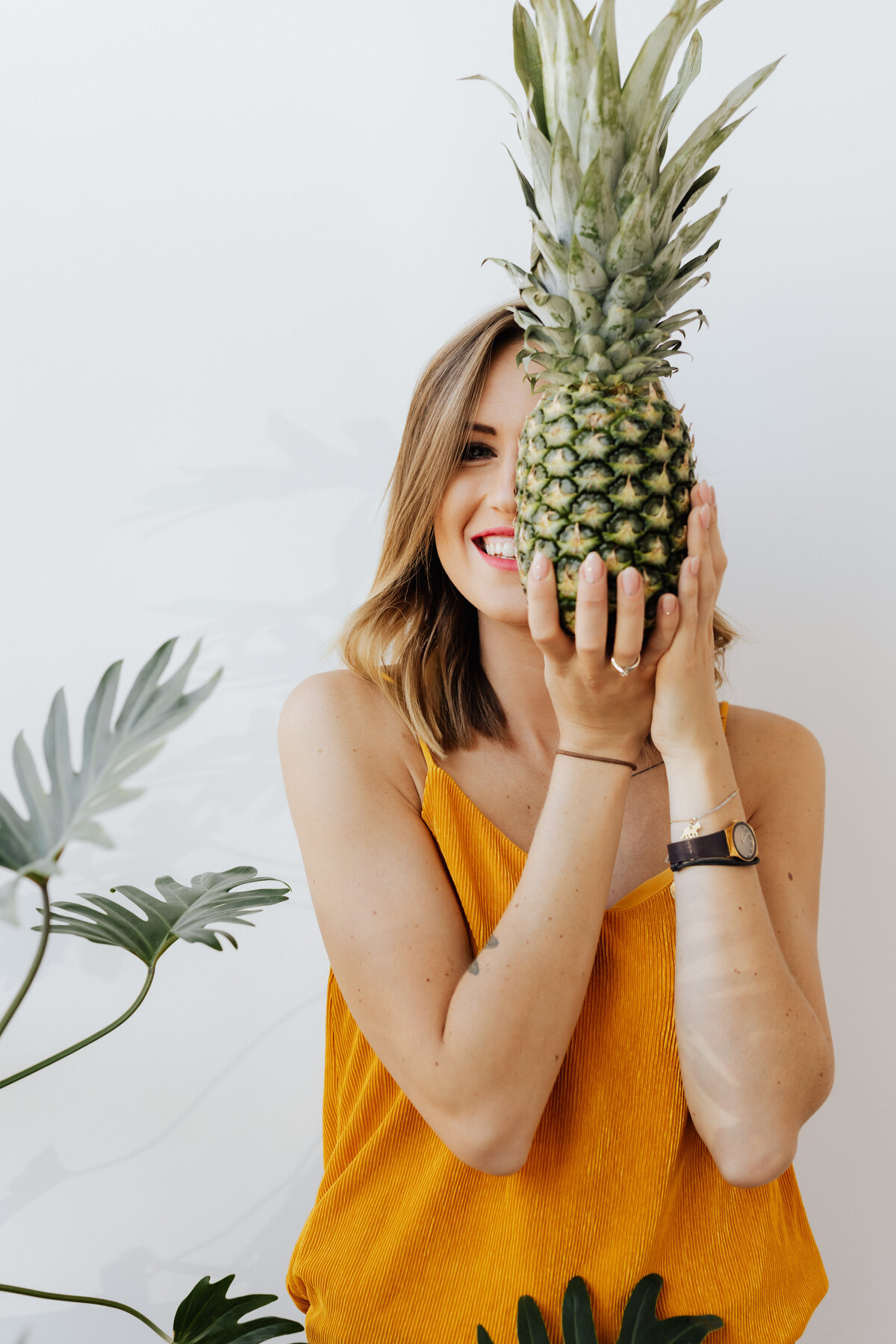 kaboompics_a-beautiful-smiling-young-woman-is-holding-a-pineapple-17670