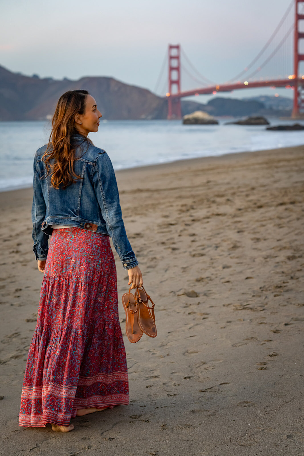 Young woman posing at the beach for a modeling portfolio with the golden gate bridge in the background