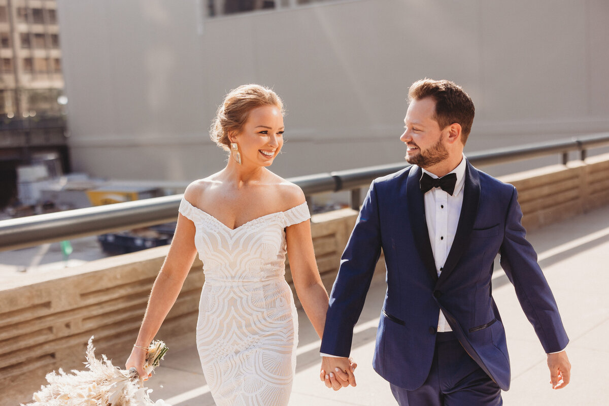 Wedding shoot of couple holding hands walking towards camera