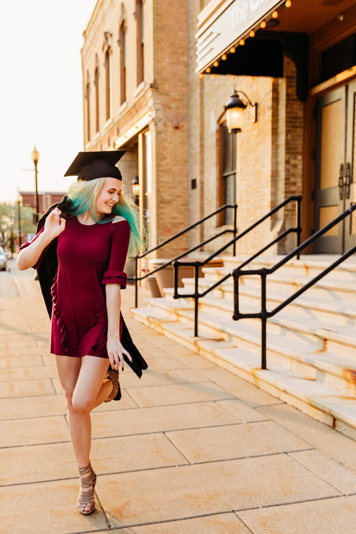 high school graduate dancing with cap and gown for senior session