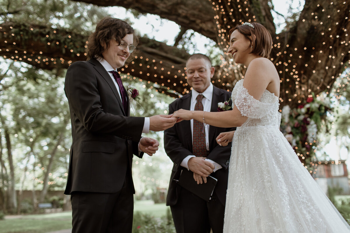 An exchange of rings under a 200-year-old oak tree at Oak Tree Manor in Spring Texas. Captured by Fort Worth wedding photographer, Megan Christine Studio