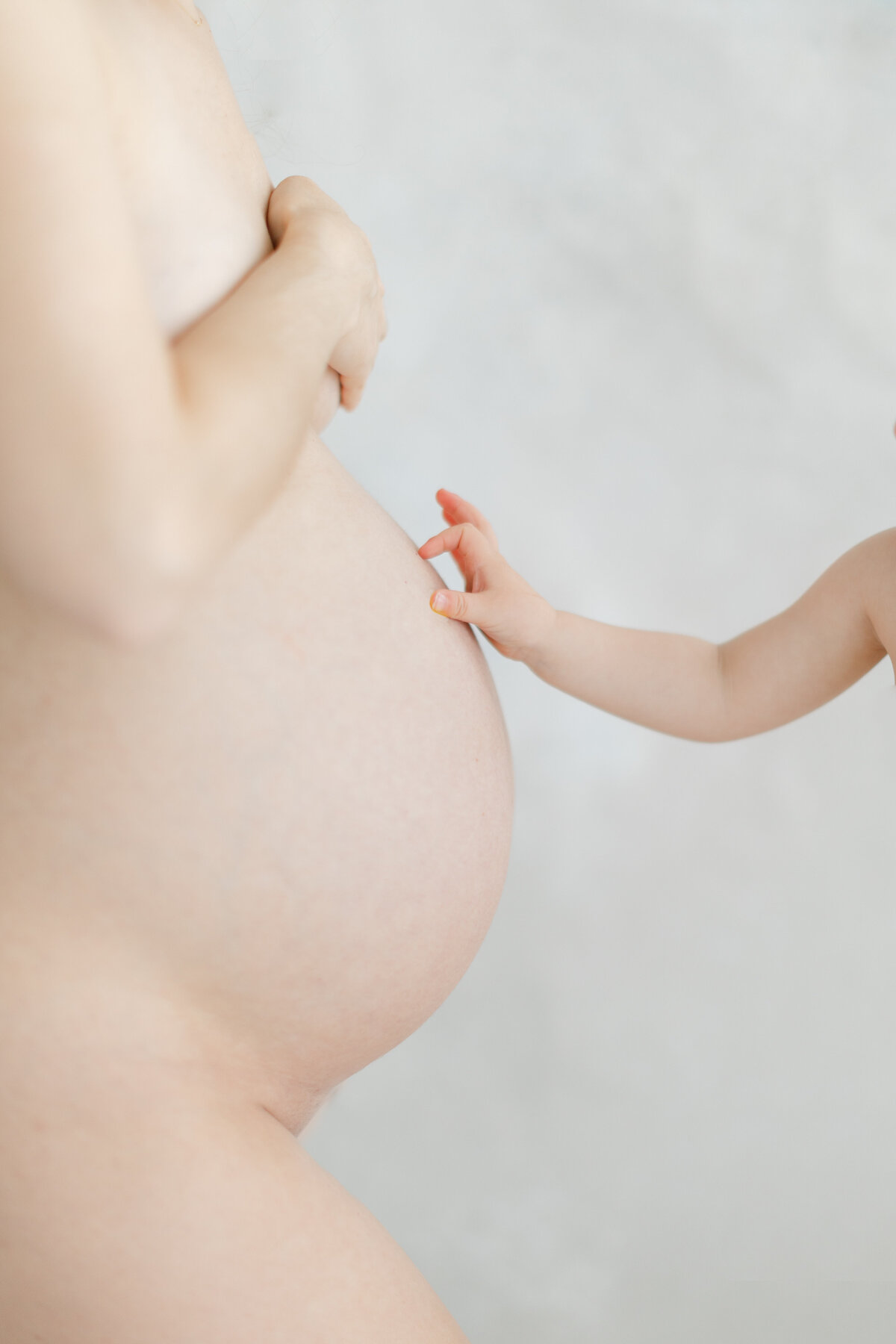 Baby reaches out to touch pregnant mama's belly