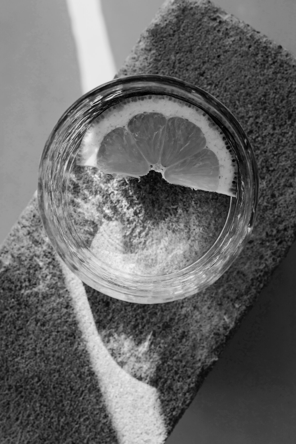 Neutral-kaboompics_Lemon slice in a glass of water