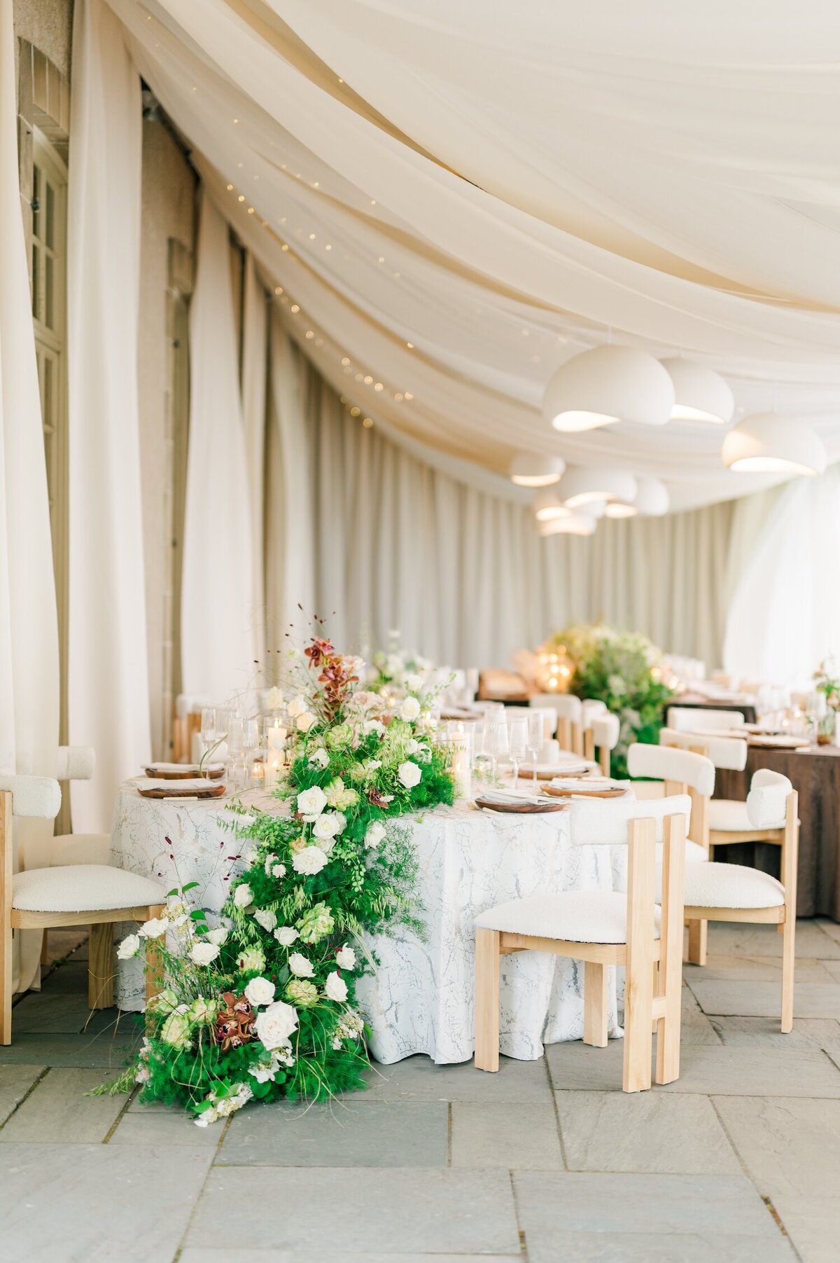 A cascading whimsical floral display on a white tablecloth at Glen Manor House. 
