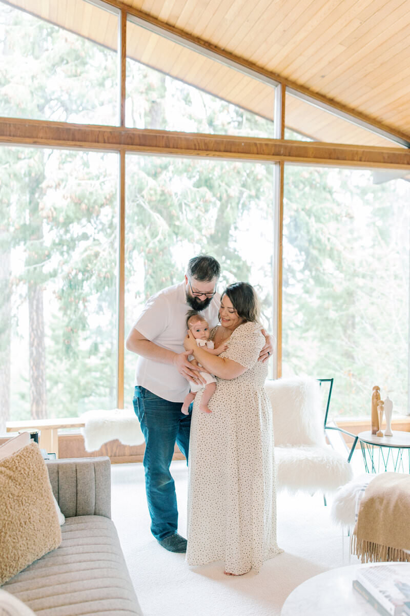 parents looking at baby in their living room by spokane photographer
