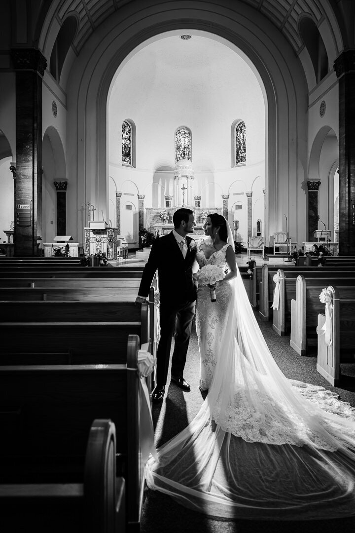 Bride and groom walking down the aisle inside a grand cathedral during their wedding ceremony in New Jersey.