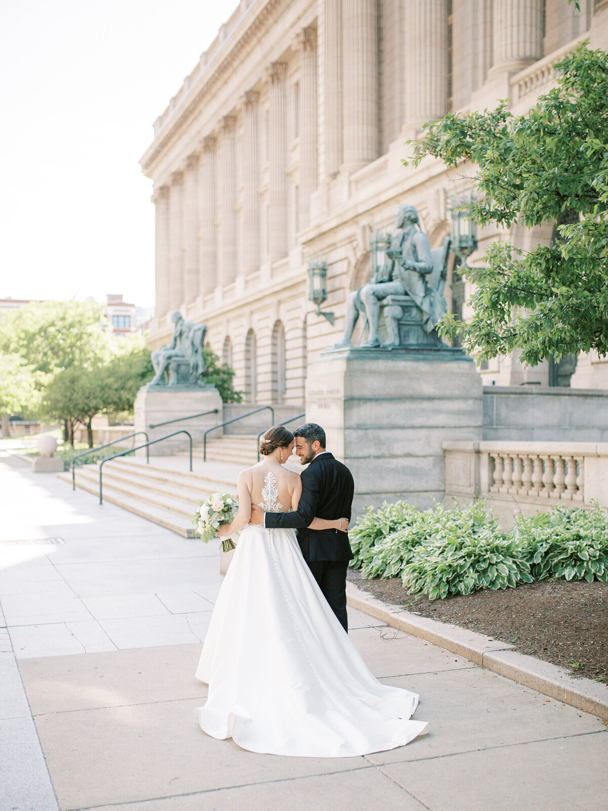 bride and groom walking together next to old courthouse in cleveland