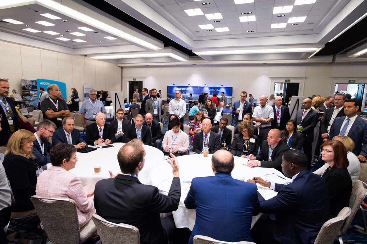 A large group gathers in the Manchester Hyatt Ballroom at round table breakout session to discuss public private partnerships