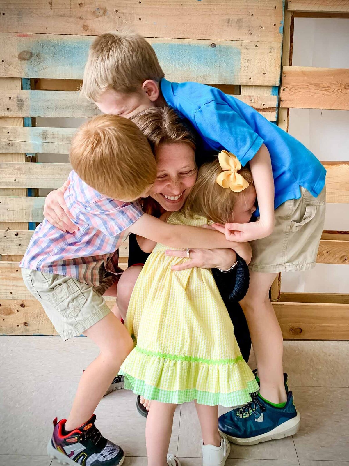 Kate Cherry with Kate Cherry Photography, LLC with her kids hugging her