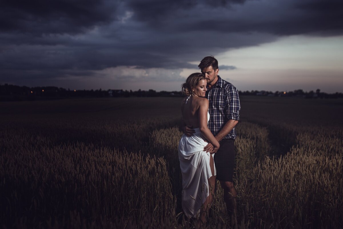 enagement-photography-couple-embracing-in-field-with-storm-approaching