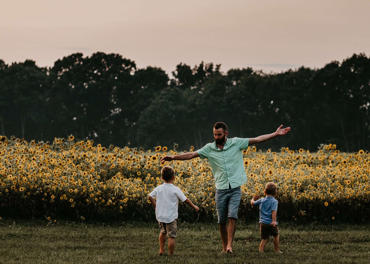 A Pittsburgh family photographer captures a father and two sons in a sunflower field.