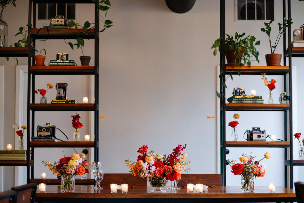 summer red orange flowers bud vases candle backdrop and sweetheart table