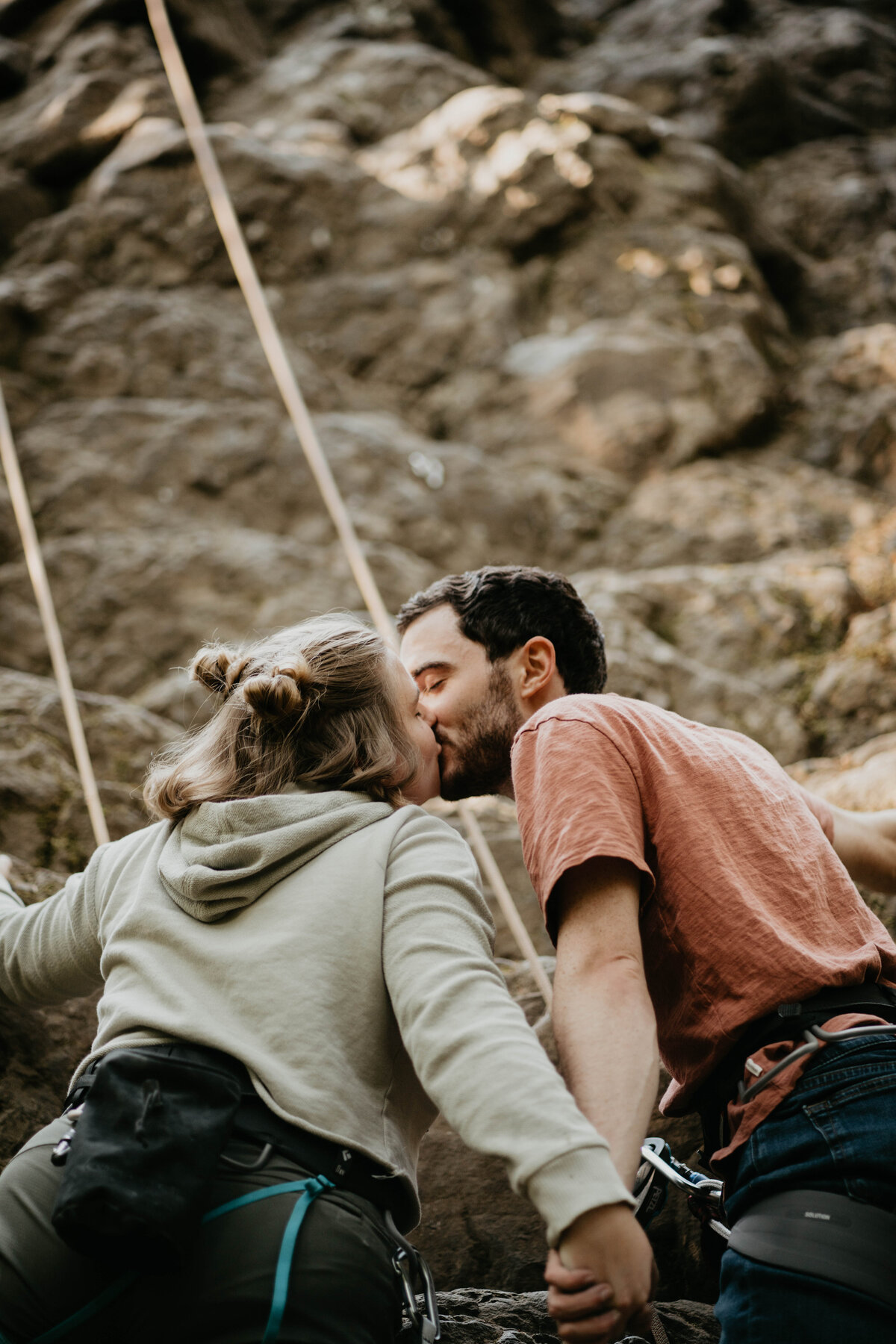 Couple kissing during rock climbing engagement photos in Oregon