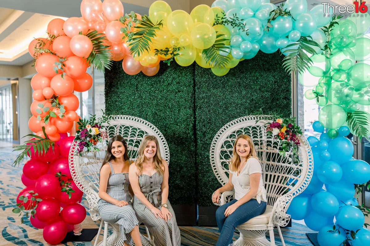 Ladies site on relaxing outdoor chairs under the balloon arechway