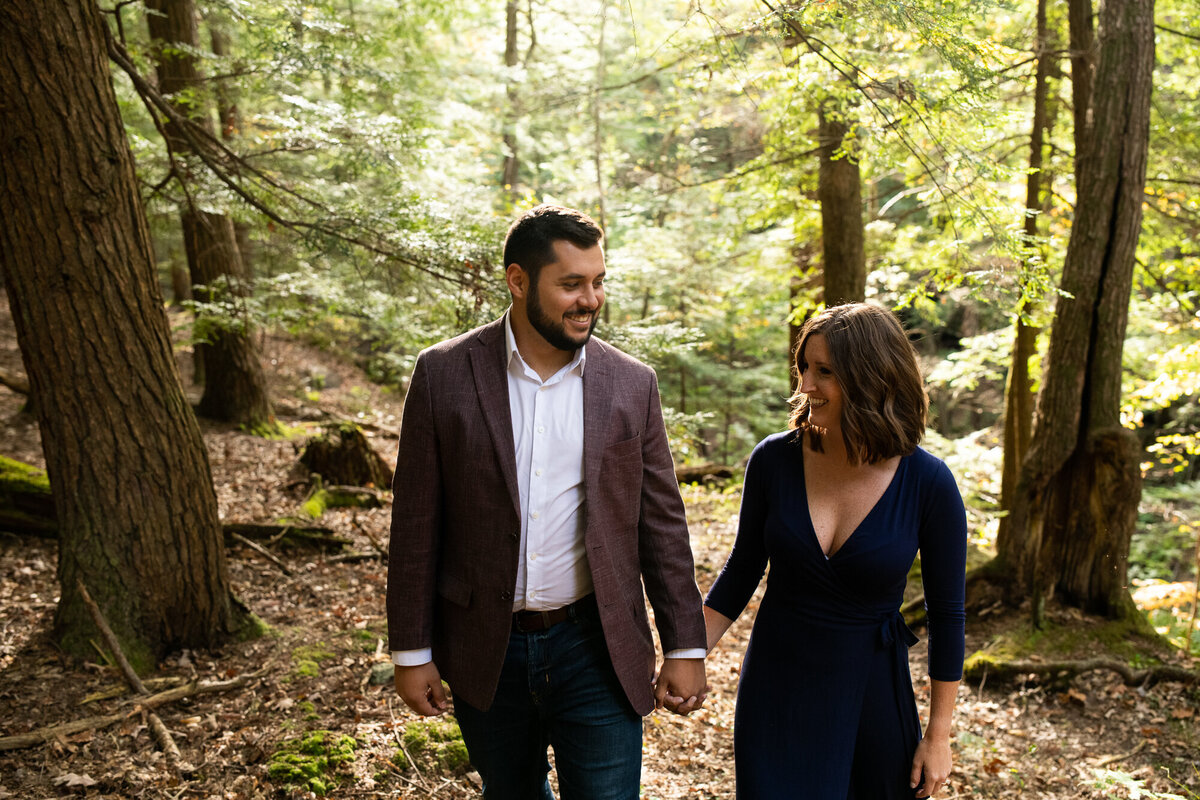 Couple walks through the forrest of Hocking Hills during their engagement session