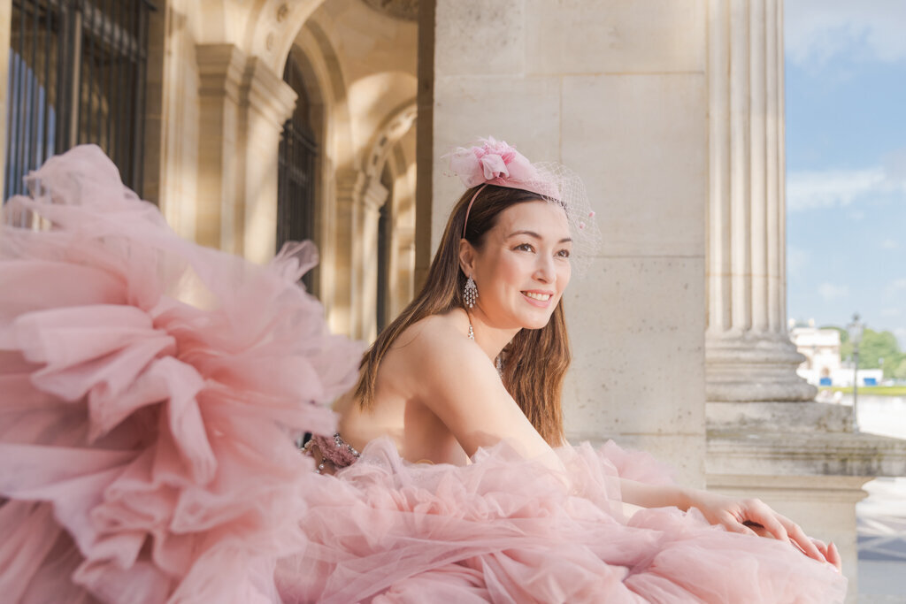 Elegant Paris portrait featuring woman in blush pink gown and matching hair piece by ornate balustrade