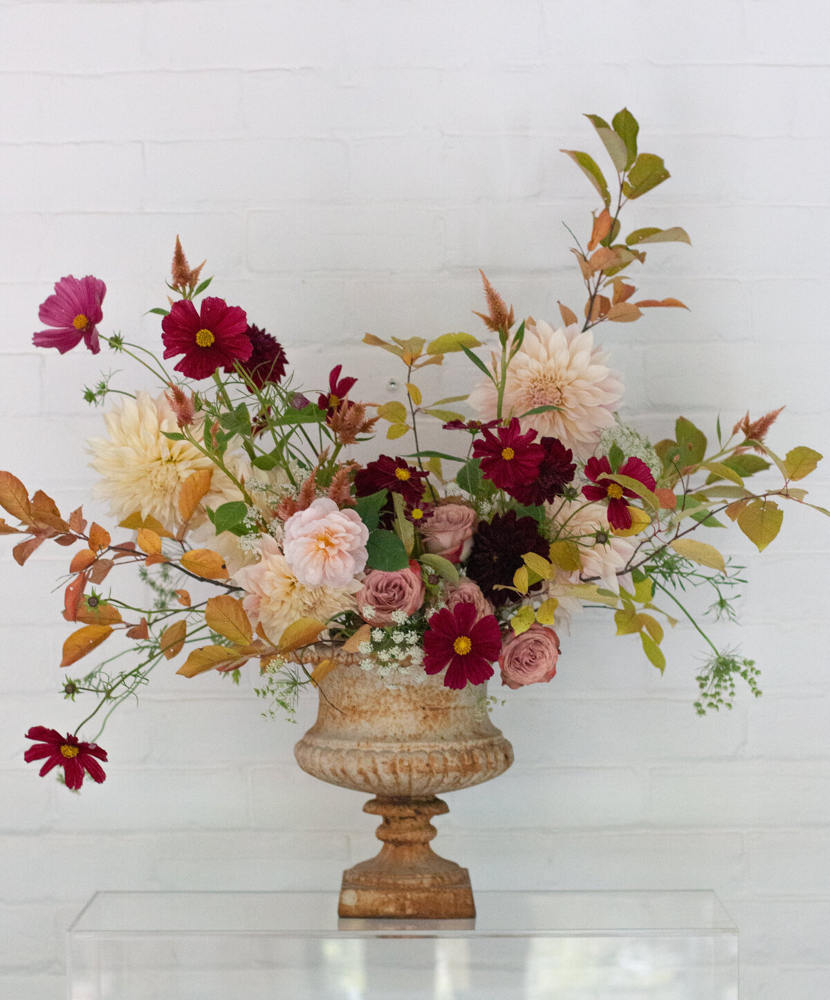 Beautiful orange and pink flowers arranged in an urn at a Montreal wedding.