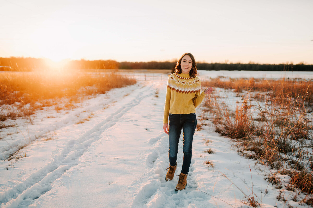 Branson senior photographer captures highs school girl walking in snow at sunset